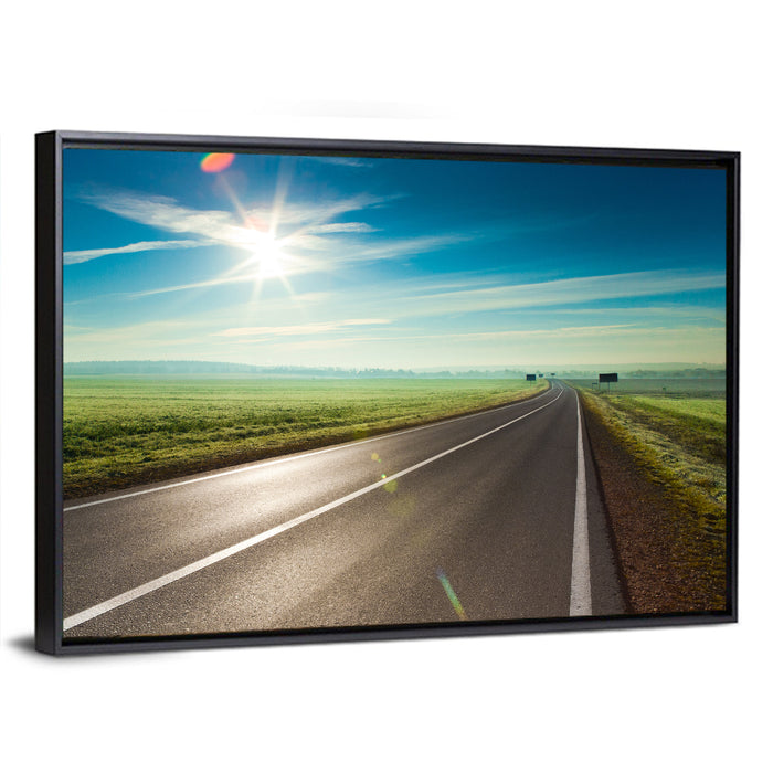 Sunlit Road Through Green Field Wall Art as a framed canvas