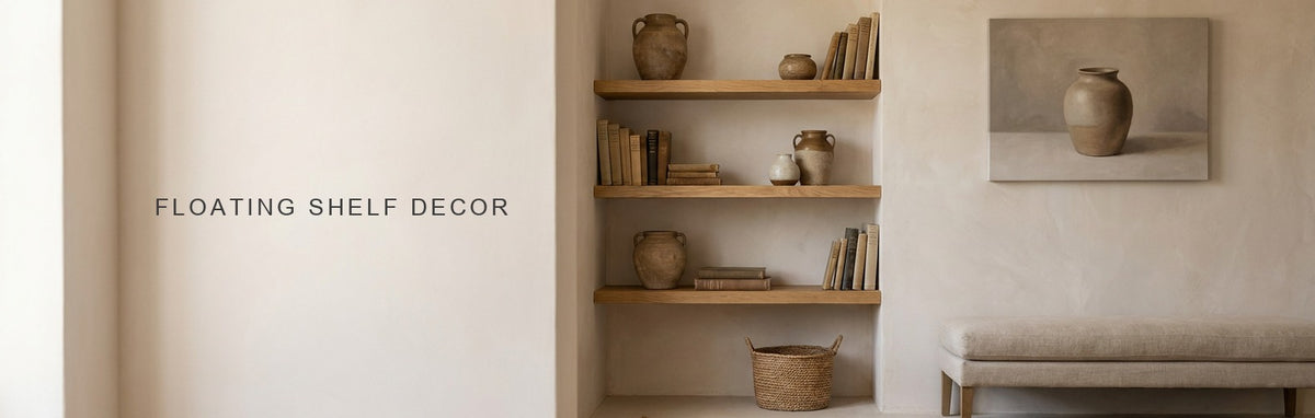Floating shelf decor in a living room alcove: two oak shelves styled with books, ceramics and a small ceramic vase still life