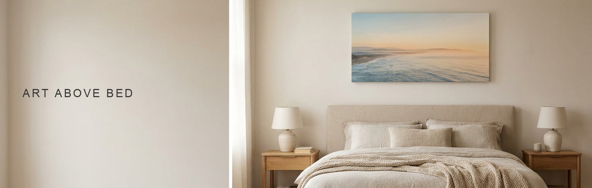 Art above bed: a wide soft coastal landscape at dawn centered over an upholstered king bed with two nightstands
