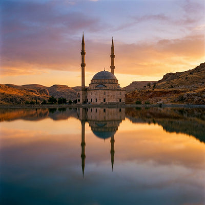 Mosque wall art: a domed mosque with slender minarets reflected in still water at sunset