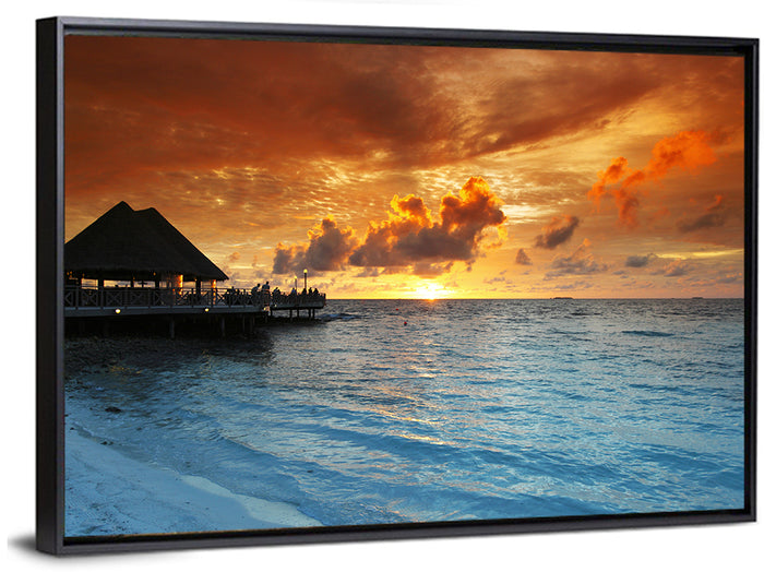 Overwater Bungalow Sunset Pier Wall Art as a framed canvas