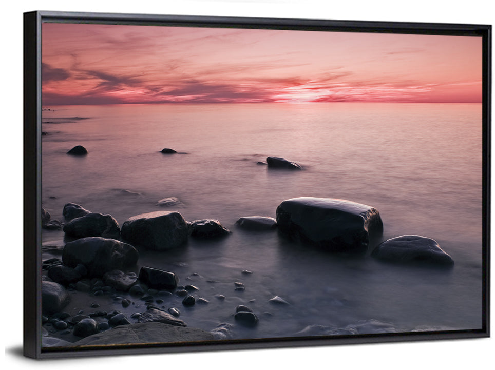 Pink Dusk Lakeshore with Silhouetted Rocks Wall Art