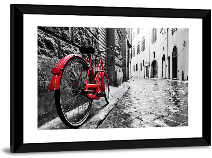 Red Bicycle on Rainy Cobblestone Street Wall Art as a framed print