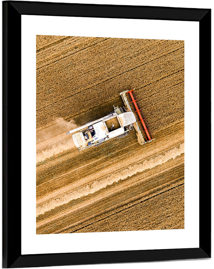 Aerial Combine Over Wheat Field Wall Art as a framed print